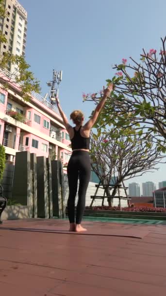 在一个大城市的摩天大楼的屋顶上 一位白人妇女正在练习瑜伽 — 图库视频影像