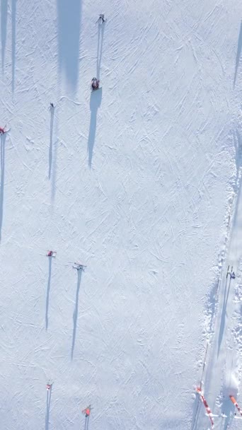 晴れた日のスキーリゾートでのスキーリフトでスキー場でスキーやスノーボードをスキーするトップビュー — ストック動画