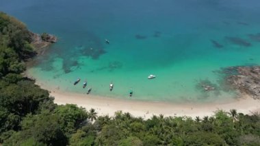 Beyaz kum, turkuaz su, geleneksel Tayland tekneleri ve lüks yatıyla Phuket Adası 'nın tropikal plajının havadan görüntüsü..
