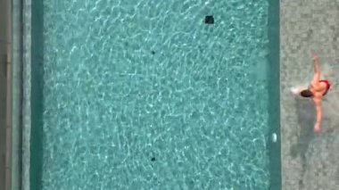 Yazın havuza atlayan adam ağır çekimde, en üst görüntüde.