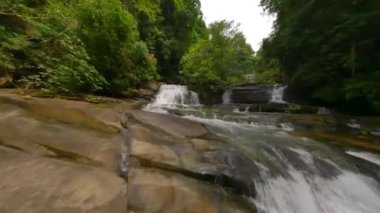 FPV, Tayland 'ın yemyeşil ormanları arasında tropikal nehir ve şelale üzerinde uçuyor..