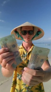 Vietnam 'da tropik plajda Vietnamlı Dong' u sayan adam..