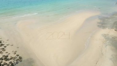 2024 yıl tropik bir plajda yazılmış. 2024 yılına girme kavramları, 2024 yılında plaj kaçamakları.