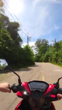 Tayland 'da tropikal bir adada motosikletle plaja giden bir adam. POV