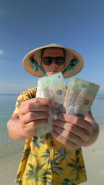 Vietnam 'da tropik plajda Vietnamlı Dong' u sayan adam..