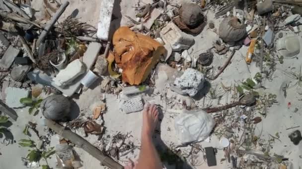 男人赤脚走在肮脏的沙滩上的垃圾中 — 图库视频影像