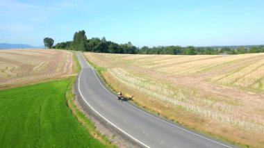 Yazın kırsal bir yolda uçan klasik motosiklet manzarası.