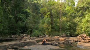 Beyaz kadın, Tayland 'da tropikal yağmur ormanlarında meditasyon yapıyor.