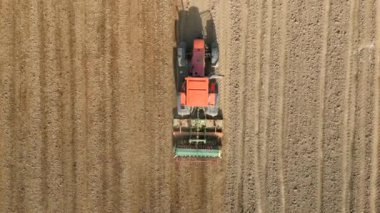 Tarlaya tahıl eken traktörün üst görüntüsü