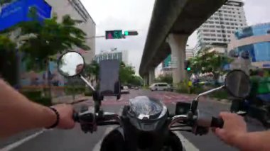 Bangkok, Tayland 'da BTS Skytrain' in yanındaki yolda motosiklet sürerken aşırı hız yapmış. POV