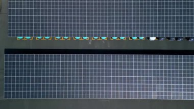 Otoparkta güneş paneli enerjisiyle çalışan elektrikli arabaların en üst görüntüsü.