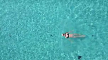 Yazın havuzda sırtüstü yüzen beyaz kadın manzarası.