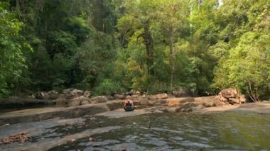 Beyaz kadın Tayland, tropikal yağmur ormanlarında meditasyon yapıyor.
