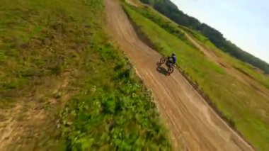 FPV insansız hava aracı bir motokros pistinde yarışçıyı kovalıyor. Yüksek hız