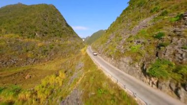 Kuzey Vietnam 'daki Ha Giang Kavşağı' nda manzaralı dağ yolunda giden kamyonun hava görüntüsü.