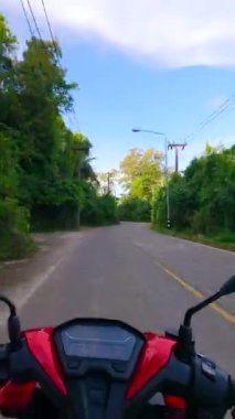 Tayland 'da tropikal bir adada motosikletle plaja giden bir adam. POV