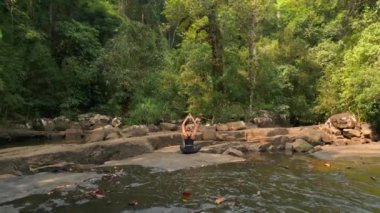 Fit beyaz kadın doğada meditasyon yapıyor.