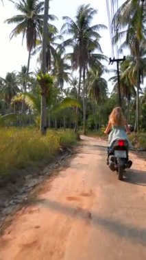 Tayland 'da tropikal yolda scooter süren beyaz kadın gezgin. Seyahat, özgürlük, tropik tatil kavramları.