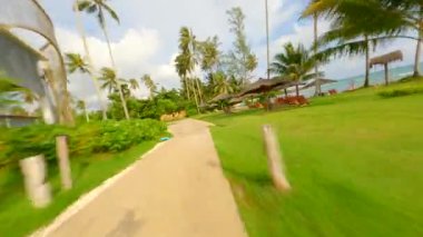FPV insansız hava aracı Tayland 'daki tropik bir adada güzel bir tatil köyünde uçuyor.