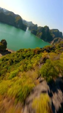 Vietnam 'daki Ha Long Körfezi' ndeki manzaralı kireçtaşı adalarına yakın sinematik FPV uçuşu.