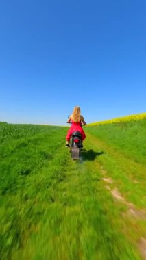 Beyaz bir kadının yaz otlaklarında klasik bir motosiklet sürüşü.