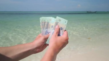 Vietnam 'da tropikal plajda Vietnamlı Dong' u sayan eller. Kapat..