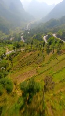 Vietnam 'daki Ha Giang Döngüsü' ndeki dağlarda pirinç terasları ve dolambaçlı yollar üzerinde sinematik FPV uçuşları.