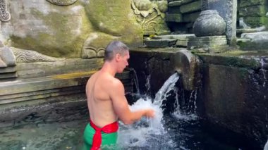 Kafkasyalı adam, Endonezya, Bali 'deki Pura Tirta Boş Tapınağı' ndaki arındırma ayininde kafasını kutsal suya daldırıyor.