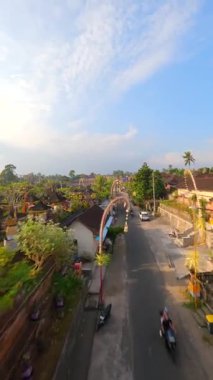 Ubud, Bali, Endonezya 'da düzenlenen Galungan tatili sırasında geleneksel köy üzerindeki sinematik FPV uçuşu.