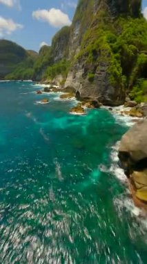 Nusa Penida, Bali, Endonezya 'daki Manta Point' teki turkuaz okyanus suları üzerinde sinematik FPV uçuşu