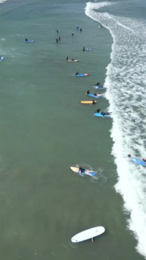 Okyanusta, Bali 'de, Endonezya' da sörf dersleri alan insanların havadan görünüşü