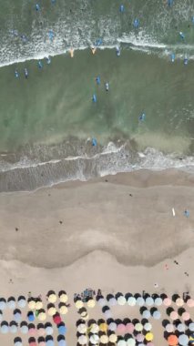 Okyanusta, Bali 'de, Endonezya' da sörf dersleri alan insanların havadan görünüşü