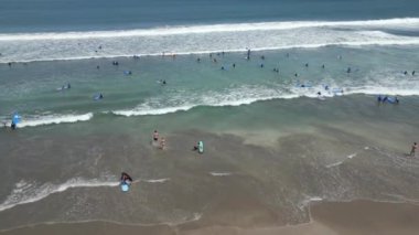 Okyanusta, Bali 'de, Endonezya' da sörf dersleri alan insanların havadan görünüşü