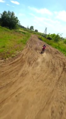 Bir motosiklet yarışçısının yüksek hızda ve ağır çekimde bir pistte FPV çekimi. Ekstrem spor, adrenalin ve yarış kavramları