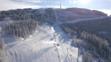 Kar yamacındaki kayakçıların ve snowboardcuların hava manzarası.