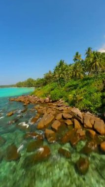 Tayland 'da turkuaz deniz bulunan tropik cennet plajı üzerinde sinematik FPV uçuşu.