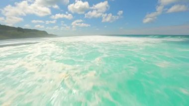 FPV, kristal berrak turkuaz su üzerinde uçuyor ve Endonezya, Bali 'de okyanus dalgaları sıçrıyor