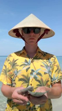 Vietnam şapkalı adam Vietnam 'daki tropik plajlarda Vietnam Dong faturalarını sayıyor.