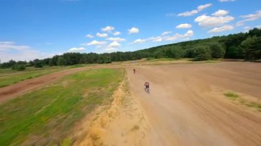 Hipodromda yüksek hızda motosiklet süren yarışçıların dinamik FPV görüntüleri. Ekstrem spor, adrenalin ve yarış kavramları.