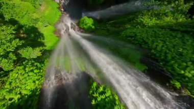 FPV insansız hava aracı Sekumpul Şelalesi, Bali, Endonezya 'nın çağlayan suları yakınında dalıyor.