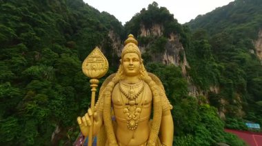 Batu Mağaralarının ve Kuala Lumpur 'un ruhani ve kültürel simgesi olan altın Murugan heykelinin FPV insansız hava aracı görüntüleri.
