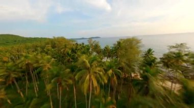 Tayland 'daki Koh Kood adasında gün batımında tropik plajlar ve turkuaz deniz üzerinde uçan FPV uçağı.