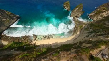 FPV İHA 'sı Nusa Penida Adası, Bali, Endonezya' daki turkuaz okyanus ve uçurumlarla simgesel Diamond Sahili 'ne dalıyor.