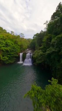Tayland 'da yemyeşil ormanlarda tropikal şelale ve nehir üzerinde FPV insansız hava aracı uçuşu.