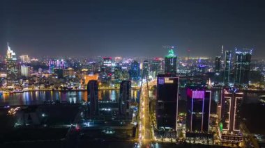 Ho Chi Minh City Saigon, Vietnam 'ın hava görüntüsü, gece parlayan gökdelenler, aydınlık gökdelenler ve nehri yansıtan trafik ışıkları