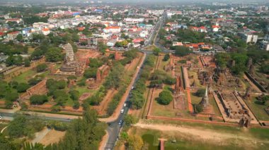 Ayutthaya, Tayland 'daki antik tapınak kalıntılarının havadan görünüşü, arka planda şehir silüeti olan tarihi Siyam mimarisini gösteren UNESCO Dünya Mirası Sitesi.