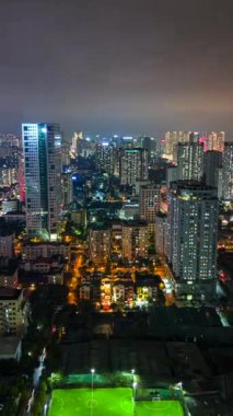 Hanoi şehrinin aydınlık gökdelenleri ve trafik ışıklarıyla aydınlanan silueti, Vietnam.