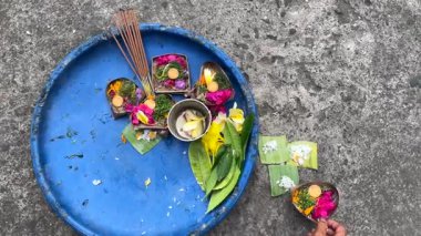 Balili bir kadının eli, Endonezya, Bali 'de geleneksel bir Hindu sabah ayini için Canang Sari sunumları hazırlıyor.
