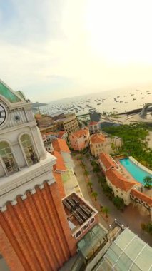 FPV insansız hava aracı, Phu Quoc Adası, Vietnam 'daki Sunset Town' da zarif merdivenlerden çıkan konik şapkalı bir kadınla birlikte uçuyor. Vietnam seyahati, kültür ve macera kavramları.