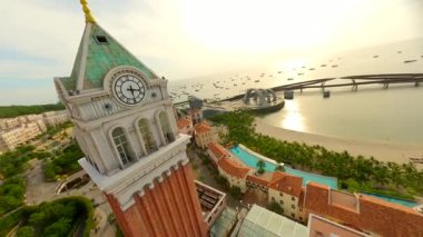 FPV insansız hava aracı, Phu Quoc Adası, Vietnam 'daki Sunset Town' da zarif merdivenlerden çıkan konik şapkalı bir kadınla birlikte uçuyor. Vietnam seyahati, kültür ve macera kavramları.